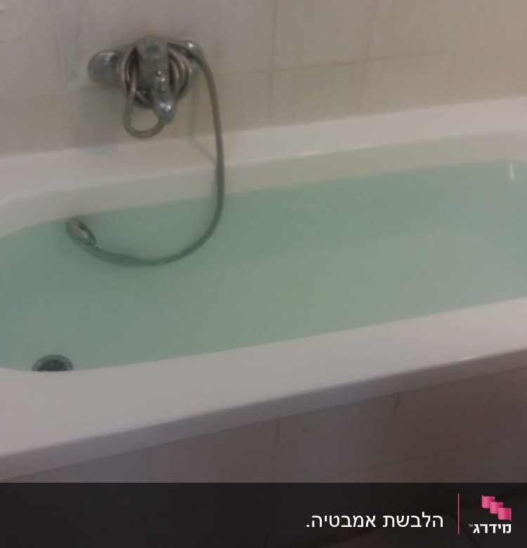 אמבטיה מלאה במים עם ברז ומקלחת